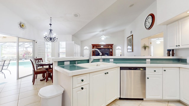 kitchen with a sink, white cabinets, vaulted ceiling, hanging light fixtures, and stainless steel dishwasher