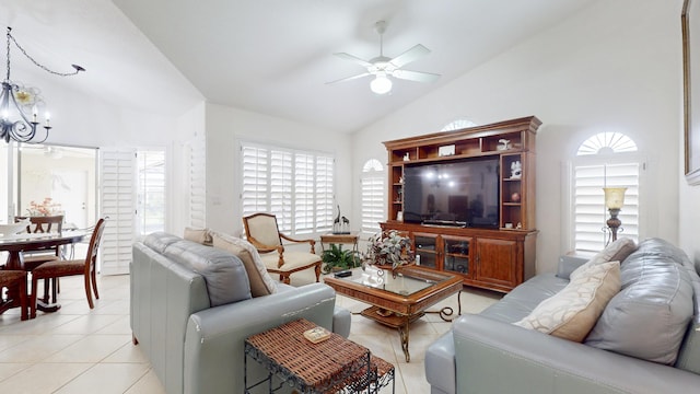 living room with lofted ceiling, ceiling fan with notable chandelier, and light tile patterned flooring