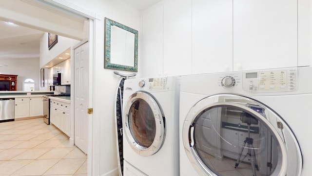 washroom with light tile patterned floors, laundry area, and washer and clothes dryer