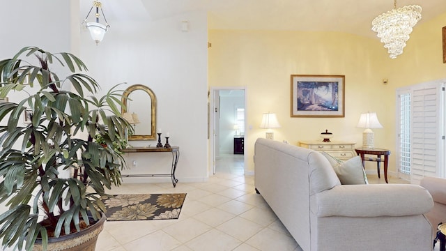 living area featuring light tile patterned floors, a high ceiling, a notable chandelier, and baseboards