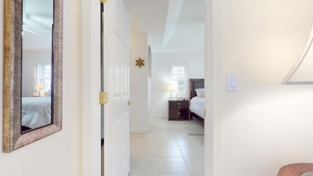 hall with light tile patterned flooring and baseboards