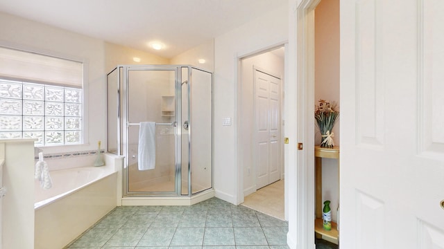 bathroom with a stall shower, tile patterned flooring, and a garden tub
