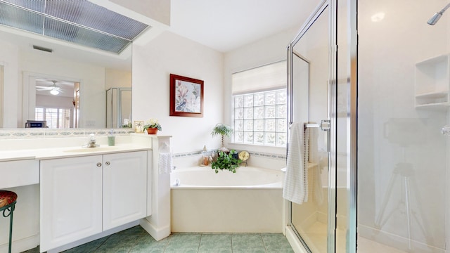 bathroom with vanity, a shower stall, a bath, and a healthy amount of sunlight