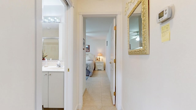 hallway with light tile patterned floors and a sink