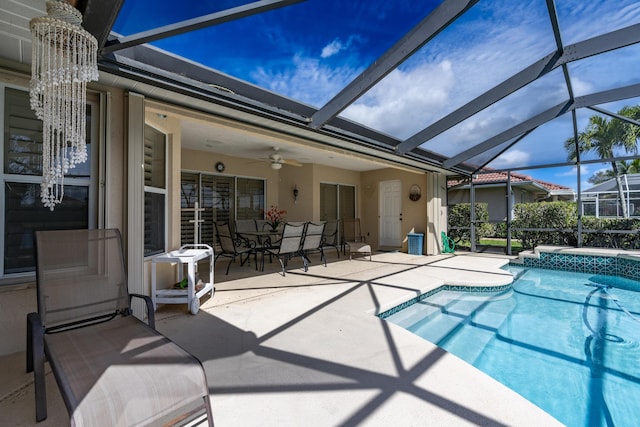 outdoor pool with glass enclosure, a patio area, and ceiling fan