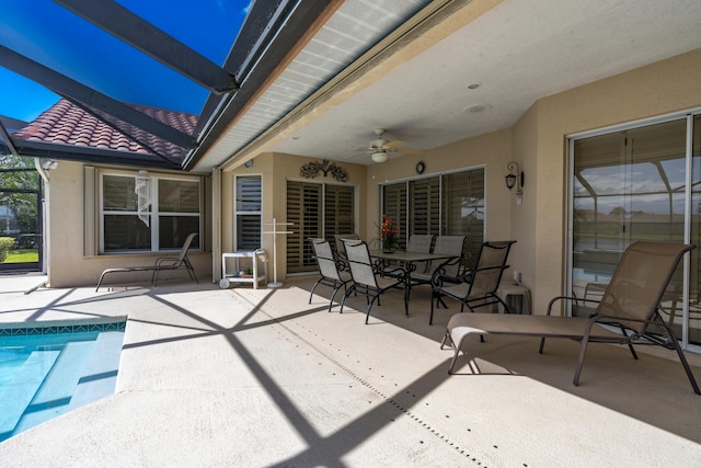 view of patio / terrace with ceiling fan, glass enclosure, and an outdoor pool
