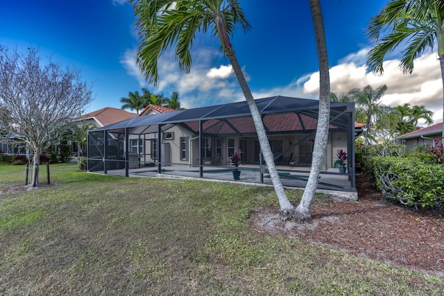rear view of property featuring a lanai, a patio area, an outdoor pool, and a lawn