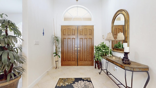 entrance foyer featuring light tile patterned flooring and baseboards