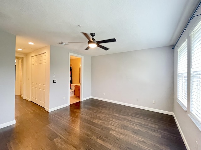 unfurnished room with a textured ceiling, recessed lighting, dark wood-type flooring, a ceiling fan, and baseboards