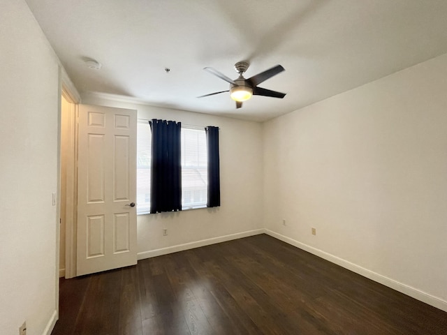 unfurnished bedroom featuring dark wood-type flooring, baseboards, and a ceiling fan