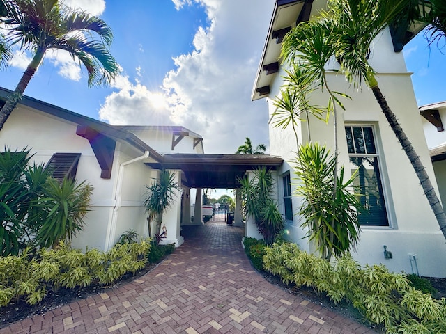 view of side of property featuring a gate and stucco siding