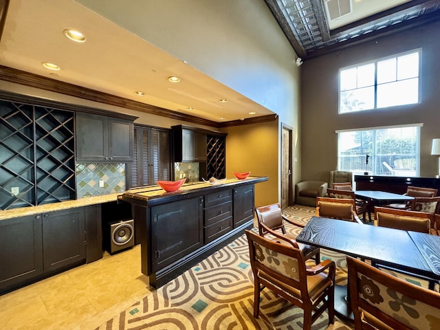 interior space featuring recessed lighting, visible vents, a towering ceiling, tasteful backsplash, and crown molding