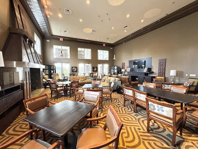 dining space with a towering ceiling, visible vents, and recessed lighting