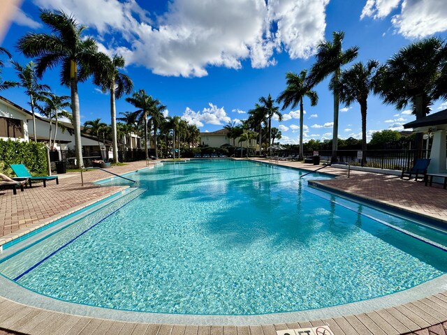 community pool featuring a patio area and fence