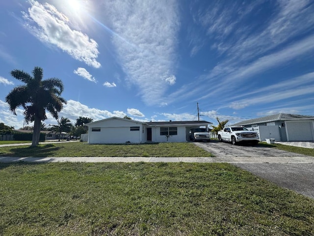 view of front facade with a front lawn and aphalt driveway