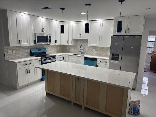 kitchen with white cabinets, stainless steel appliances, and decorative light fixtures