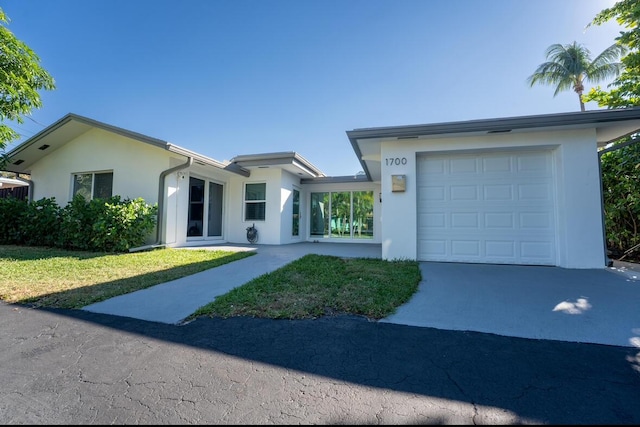 view of front facade featuring stucco siding, an attached garage, and concrete driveway