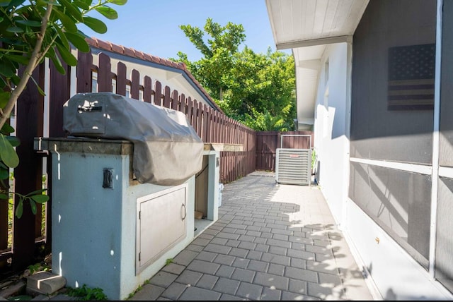 view of patio / terrace with grilling area, central AC unit, and fence