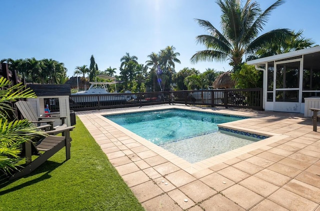 view of pool with a fenced in pool, a sunroom, and a patio area