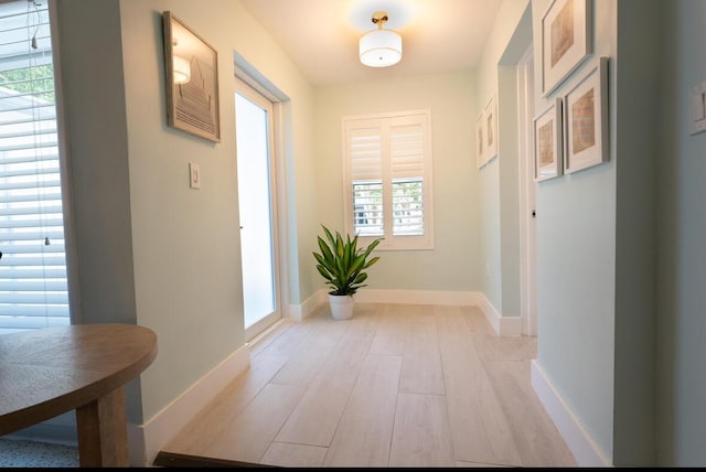 foyer with light wood-style flooring and baseboards