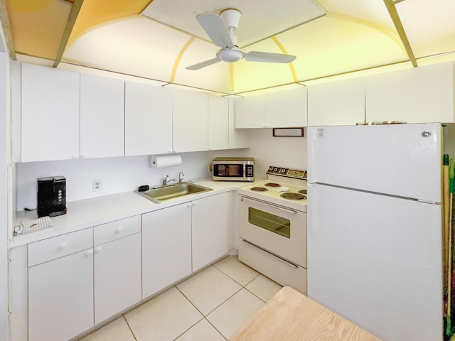 kitchen with white appliances, light tile patterned floors, light countertops, white cabinetry, and a sink