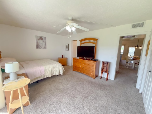 carpeted bedroom featuring visible vents and a ceiling fan