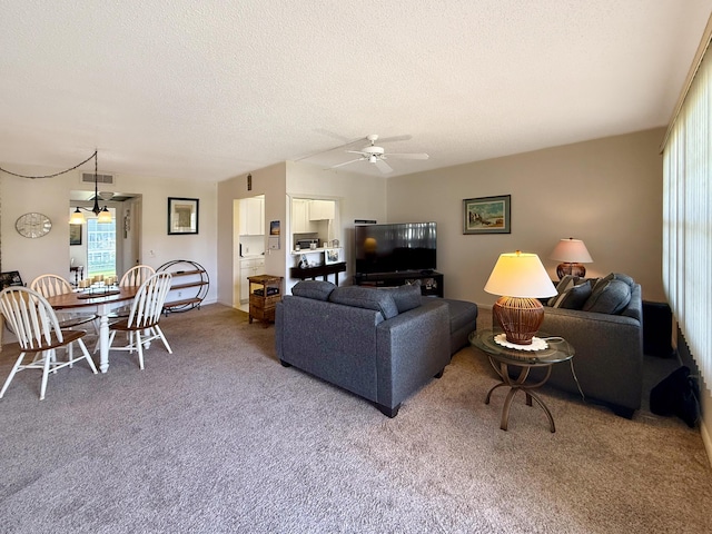 living room featuring a ceiling fan, carpet, visible vents, and a textured ceiling