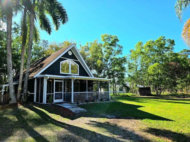 back of property with a lawn and a sunroom