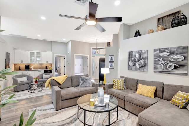 living area featuring ceiling fan, light wood-style flooring, visible vents, and recessed lighting