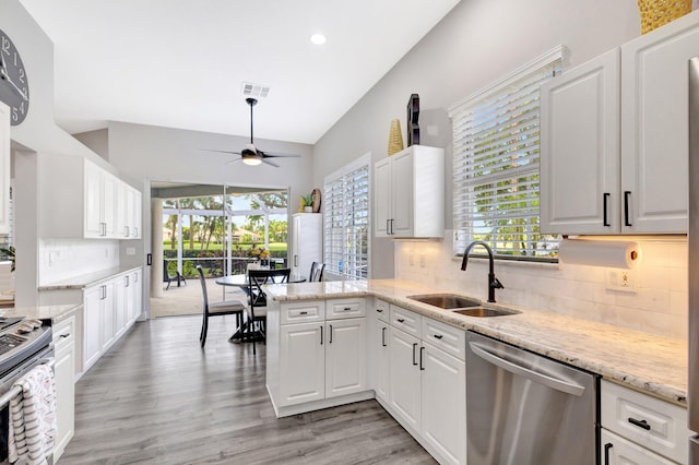 kitchen with stainless steel appliances, a wealth of natural light, white cabinetry, and a sink