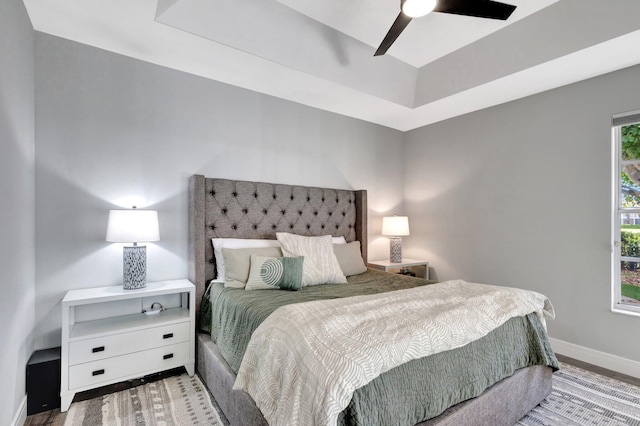 bedroom with wood finished floors, a ceiling fan, and baseboards