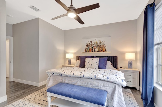 bedroom featuring visible vents, a ceiling fan, light wood-type flooring, multiple windows, and baseboards