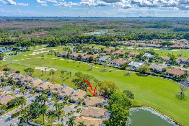 drone / aerial view featuring a residential view, view of golf course, and a water view