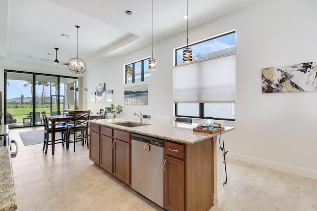 kitchen with visible vents, a raised ceiling, light stone countertops, stainless steel dishwasher, and a sink