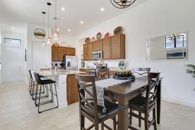 dining area featuring light tile patterned floors, visible vents, baseboards, a high ceiling, and recessed lighting