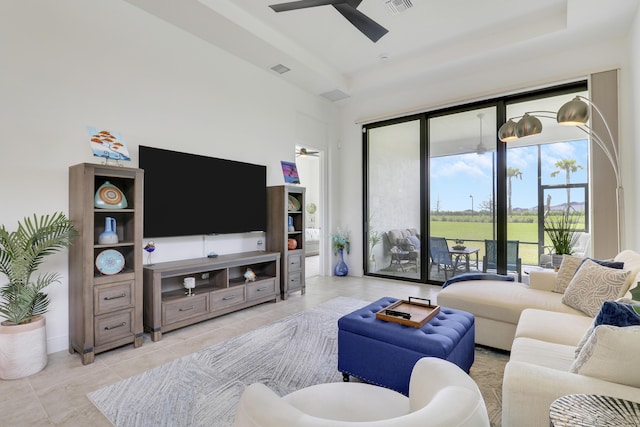 living room featuring a raised ceiling, visible vents, ceiling fan, and light tile patterned floors