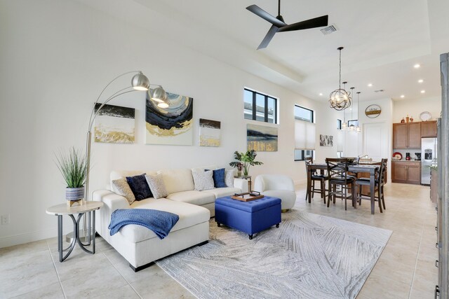 living room featuring light tile patterned floors, recessed lighting, visible vents, baseboards, and ceiling fan with notable chandelier