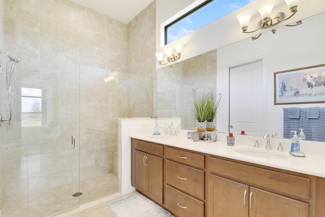 full bath featuring double vanity, an inviting chandelier, a shower stall, and a sink