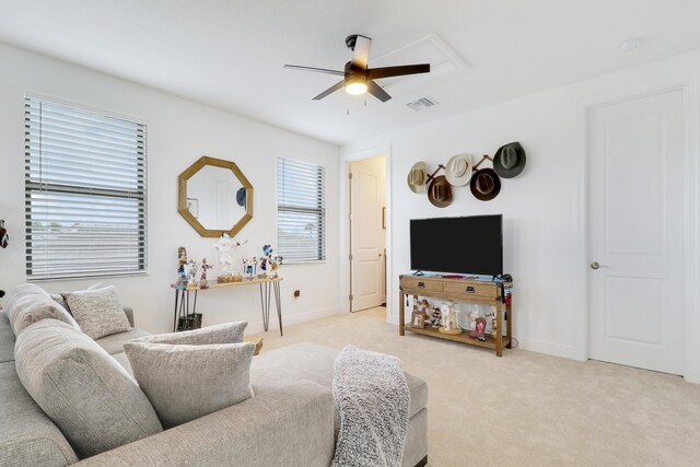 living area with light carpet, ceiling fan, visible vents, and baseboards