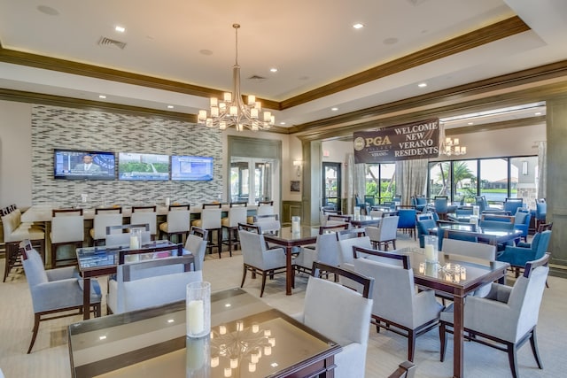 interior space featuring a chandelier, a tray ceiling, visible vents, and crown molding