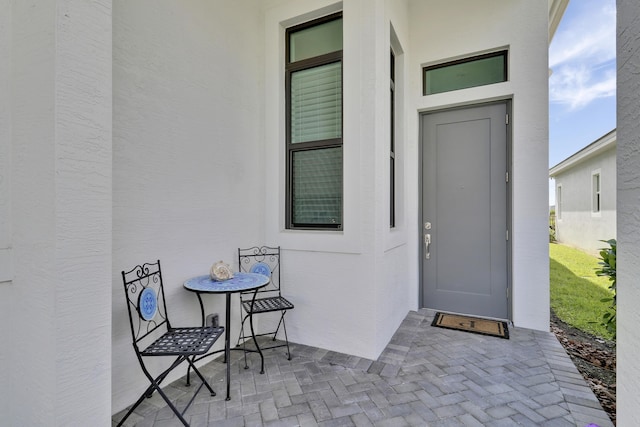 property entrance featuring a patio and stucco siding