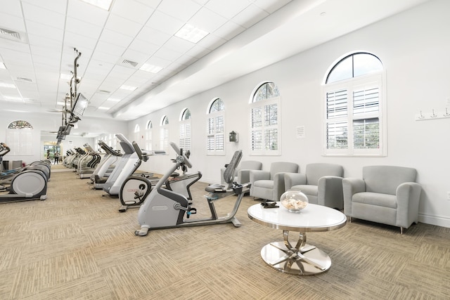 exercise room featuring visible vents, baseboards, a drop ceiling, and light colored carpet