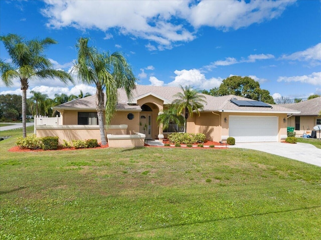 ranch-style home with stucco siding, driveway, a front lawn, roof mounted solar panels, and an attached garage