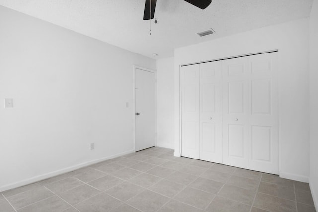 unfurnished bedroom featuring a textured ceiling, a closet, visible vents, and baseboards