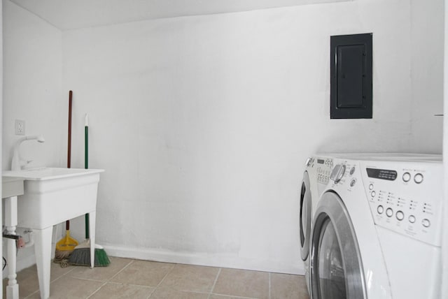 clothes washing area featuring light tile patterned floors, laundry area, baseboards, independent washer and dryer, and electric panel