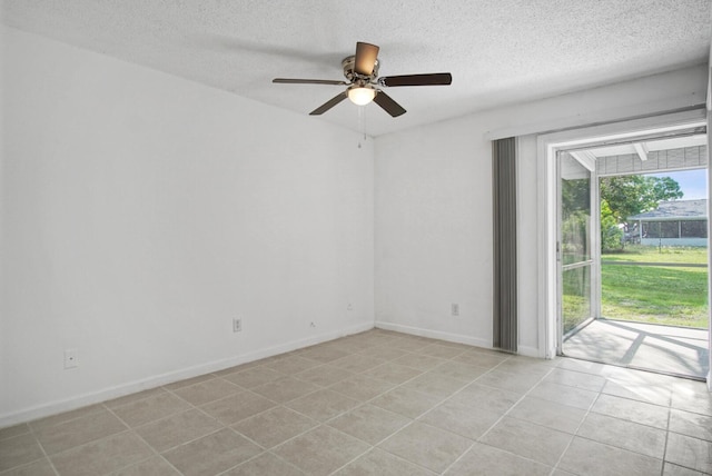 spare room with light tile patterned floors, a ceiling fan, baseboards, and a textured ceiling