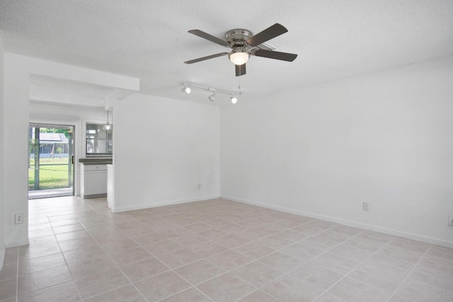 empty room featuring a ceiling fan, a textured ceiling, baseboards, and light tile patterned floors