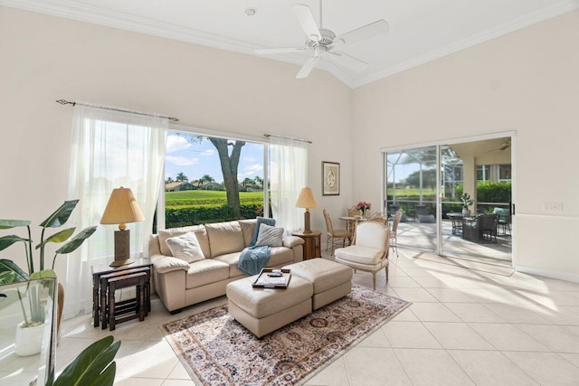 living area featuring light tile patterned floors, a towering ceiling, ornamental molding, a ceiling fan, and a sunroom