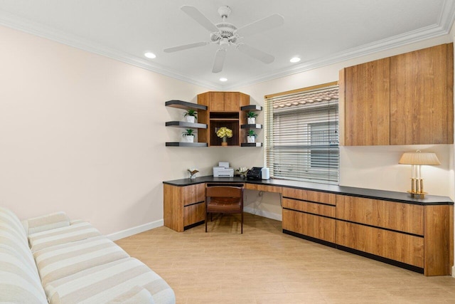 office area with a ceiling fan, built in study area, crown molding, and baseboards