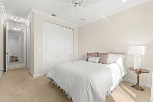 bedroom with a closet, light carpet, crown molding, and visible vents